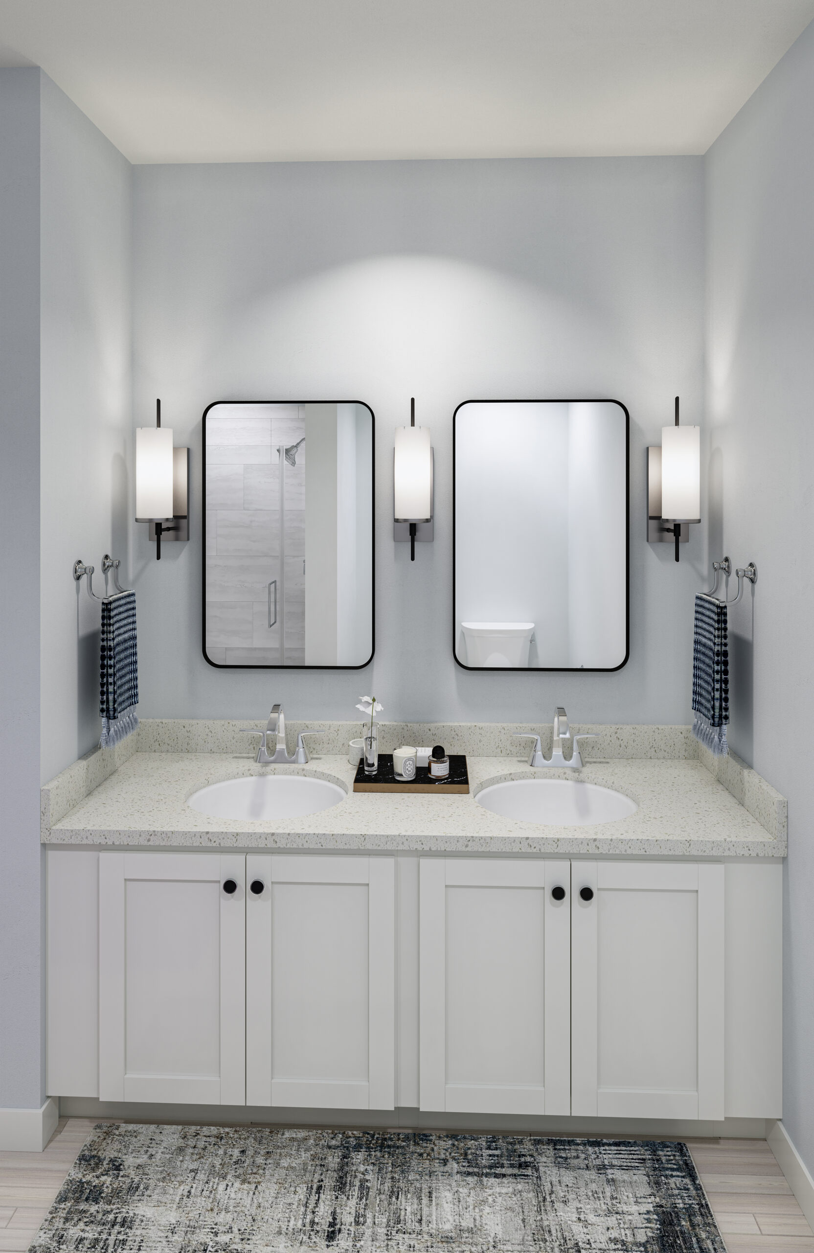 Luxury apartment bathroom with double sink vanity, storage cabinets below that countertop, and large rectangular mirrors above each sink.